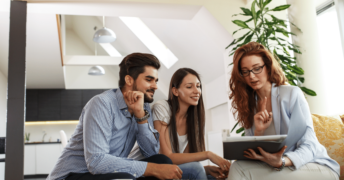 Three people sitting on a couch looking at a tablet reading about payday loan relief