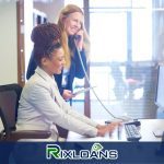 Two women sitting at a desk talking on the phone about payday loans in Connecticut