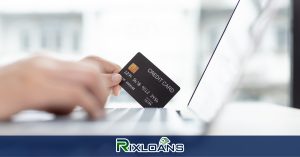 man holding a card while using a laptop