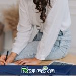 A woman sitting on a table writing notes on a piece of paper about what heppens at the date of a payday loan maturity