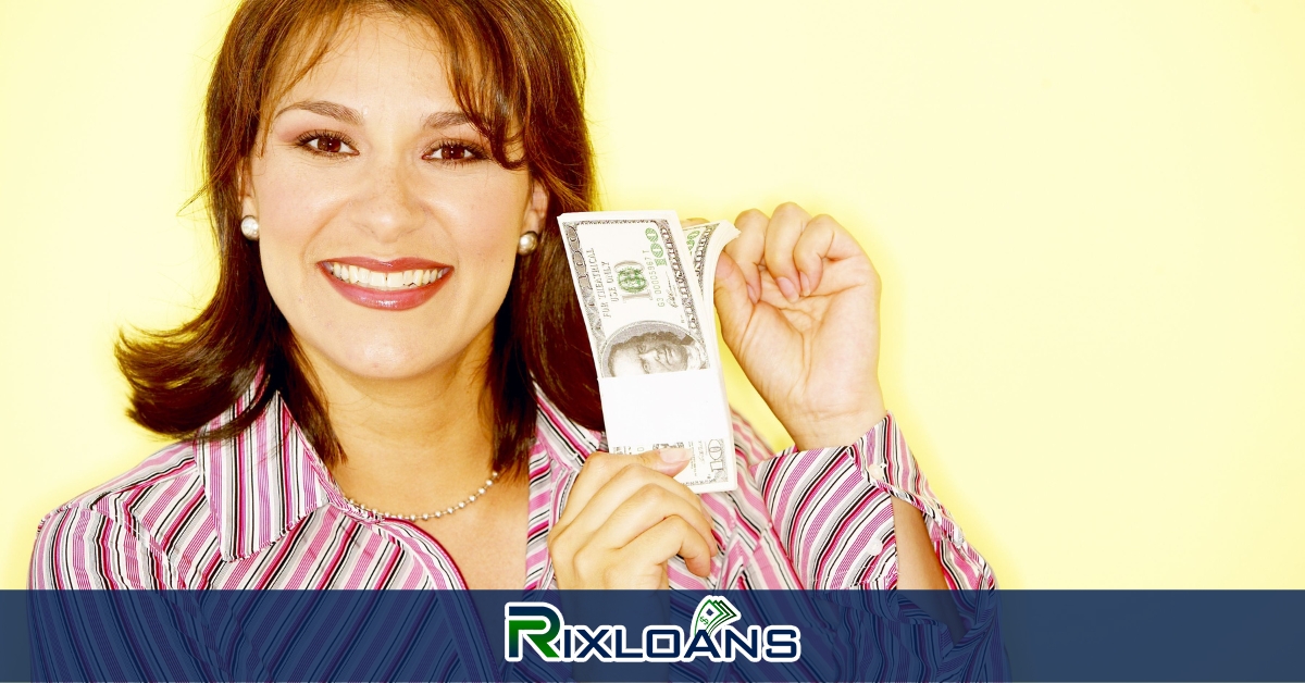 A woman holding a bundle of money obtained from a same day loan in front of her face