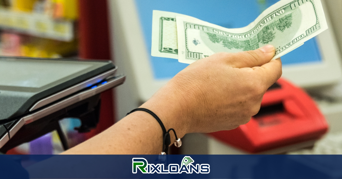 A person holding a dollar bill obtained from a payday loan in Alabama in front of a machine