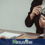 A person sitting at a desk holding money obtained from a payday loan in South carolina