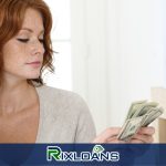A woman holding a stack of money in her hand while looking for ways to consolidate her payday loans in Delaware