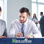 Two men in business attire looking at a computer screen containing the various ways of consolidating payday loans in Michigan