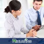 A man and woman sitting at a desk with a clipboard learning about how to consolidate payday loans in Ohio