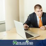 A man sitting at a table with a laptop in front of him looking for ways to consolidate payday loans in Utah