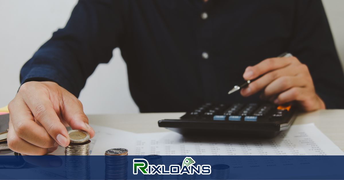 A man sitting at a table with a calculator and a stack of coins trying to find out the difference between a payday loan and a tribal loan