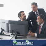 Three men in suits are sitting in front of a computer comparing payday loans Phoenix