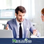 A man and a woman sitting in front of a laptop computer discussing installment loans in Maine