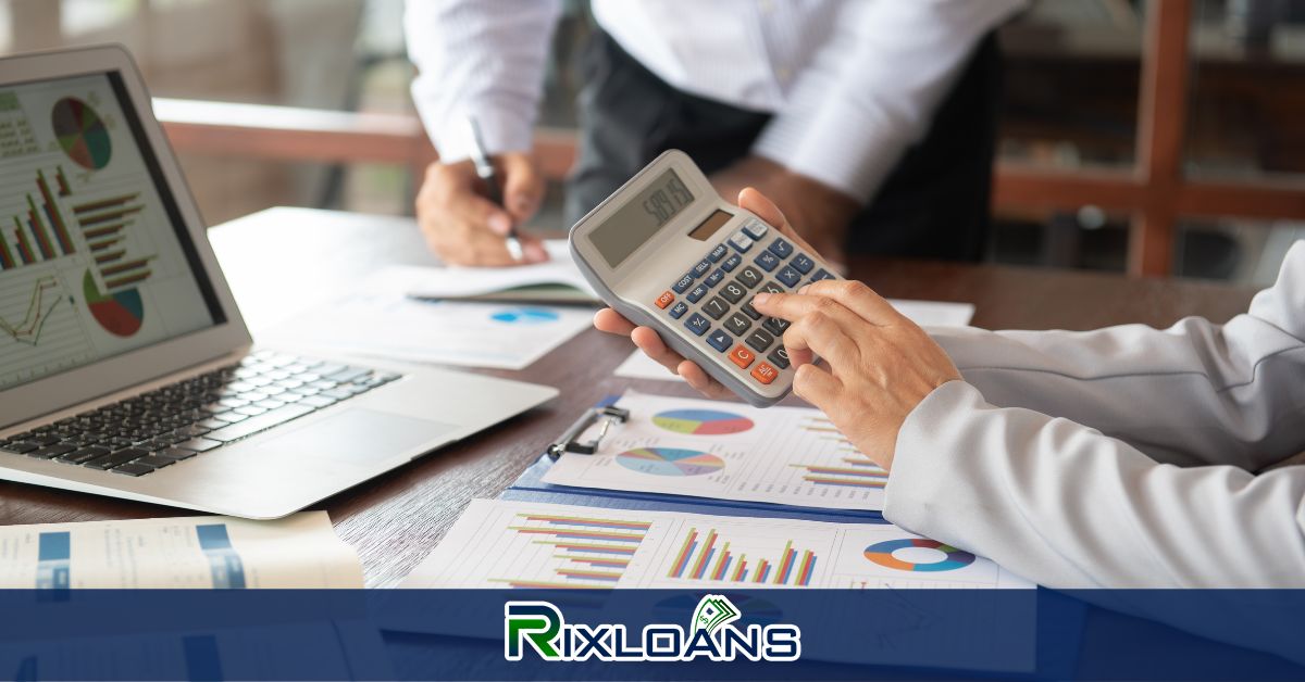 A person holding a calculator in front of a laptop working on installment loans charts in New York