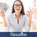 A woman holding a fan of money from installment loans Tennessee in front of a laptop