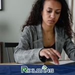 A woman sitting at a desk searching for installment loans on a laptop in Vermont