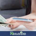 A woman holding a smart phone and a stack of money from installment loans Virginia
