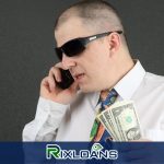 A man talking on a cell phone while holding money from installment loans Wisconsin